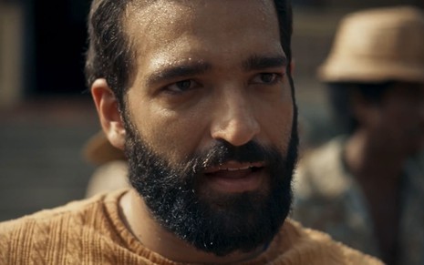 Humberto Carrão caracterizado como José Inocêncio; ele dá um sorriso vitorioso em cena de Renascer