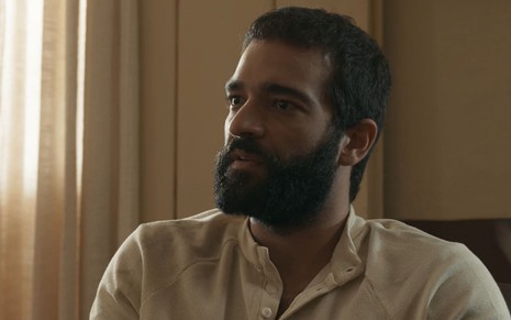 Humberto Carrão caracterizado como José Inocêncio; ele dá um leve sorriso em cena de Renascer