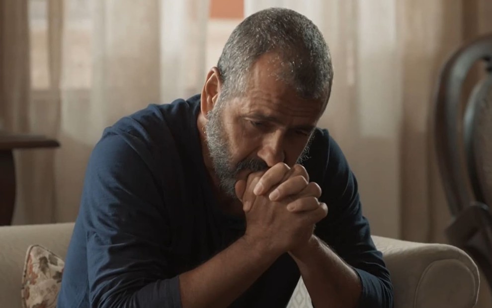 Marcos Palmeira caracterizado como José Inocêncio; ele está com as mãos cruzadas próximas ao rosto e transparece desespero