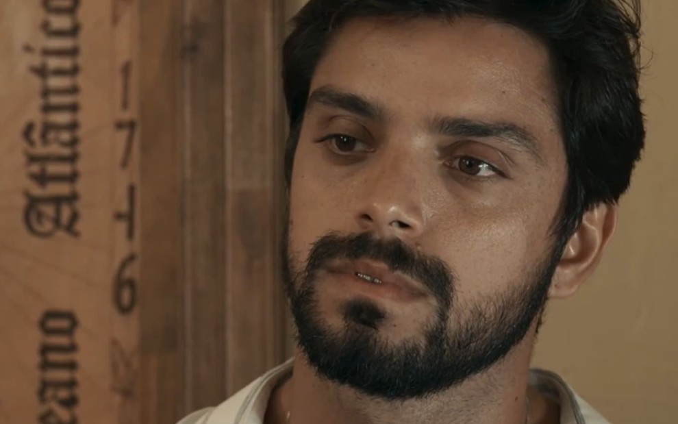 Rodrigo Simas caracterizado como José Venâncio; ele está sério em cena de Renascer