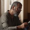 Marcos Palmeira como José Inocêncio utilizando um óculos para perto e lê uma revista em cena de Renascer