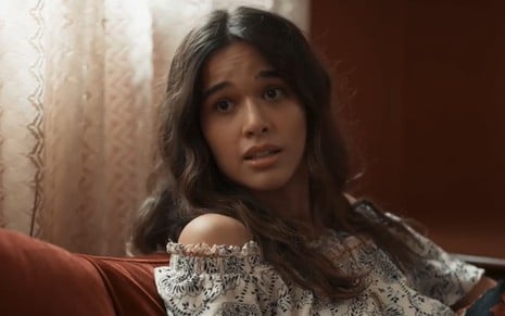 Theresa Fonseca caracterizada como Mariana; ela está séria em cena de Renascer