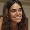 Theresa Fonseca caracterizada como Mariana; ela dá um sorriso sedutor em cena de Renascer
