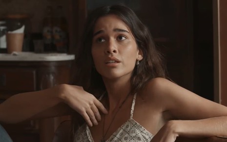 Theresa Fonseca caracterizada como Mariana; ela exprime confusão em cena de Renascer