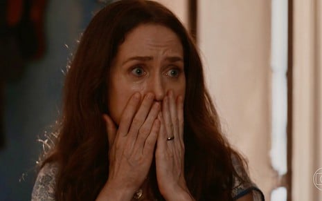 A atriz Camila Morgado com as mãos na frente da boca, expressão de medo em cena de Renascer