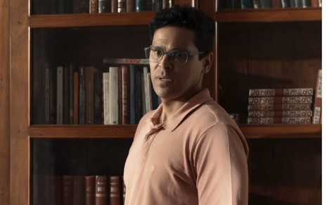 Renan Monteiro como José Augusto em frente a uma estante cheia de livros na novela Renascer