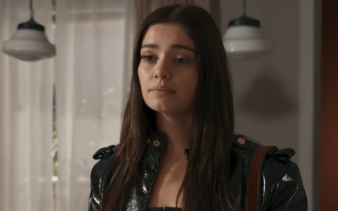 Sophie Charlotte caracterizada como Eliana; ela está séria e usa uma jaqueta de couro em cena de Renascer