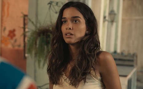 Theresa Fonseca caracterizada como Mariana; ela está séria em cena de Renascer