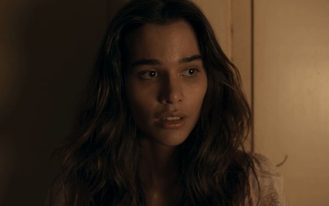 Theresa Fonseca caracterizada como Mariana; ela está encostada numa porta e finge que está boquiaberta em cena de Renascer