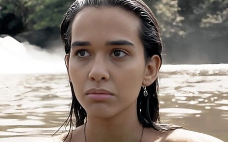 Theresa Fonseca está dentro da água de uma cachoeira em cena da novela Renascer, da Globo, como Mariana