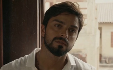 Rodrigo Simas usa camisa clara em cenário do remake de Renascer como o personagem José Venâncio