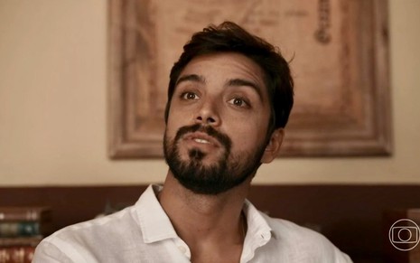 O ator Rodrigo Simas usa camisa clara em cena de Renascer; ele está caracterizado como José Venâncio