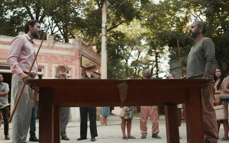 Vladimir Brichta como Egídio joga uma partida de sinuca no meio da rua com Marcos Palmeira, o José Inocêncio, em cena de Renascer