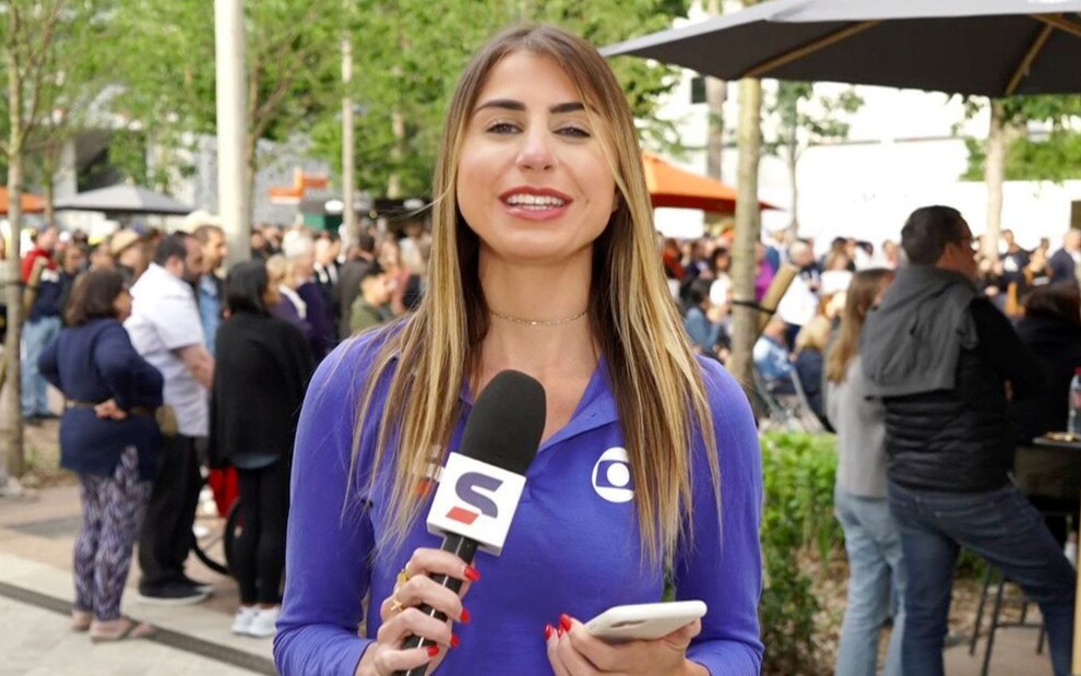 Renata Heilborn com um microfone com o símbolo do SporTV