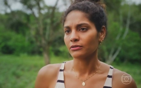 A atriz Barba Reis usa regata listrada e tem os cabelos presos em cena como Aline na novela Terra e Paixão, da Globo