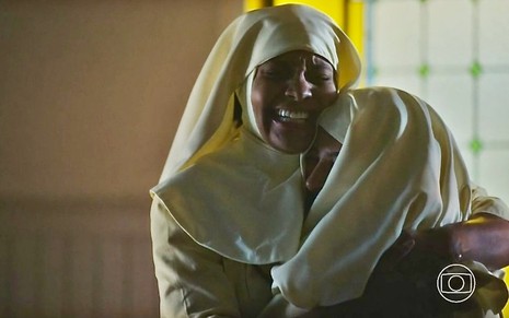 Barbara Reis veste roupa de freira e abraça Laura Prado em cena da novela Terra e Paixão, da Globo
