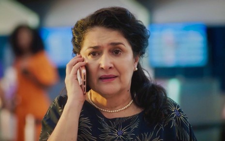 A atriz Inez Viana fala ao celular em cena da novela Terra e Paixão como Angelina