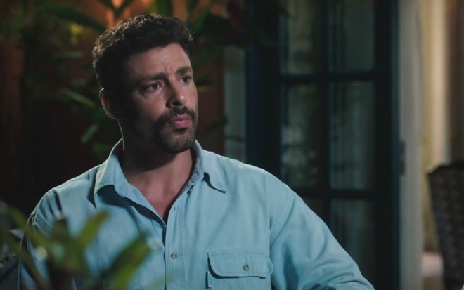 O ator Cauã Reymond está sério em cena da novela Terra e Paixão caracterizado como Caio