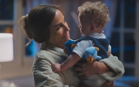 Gloria Pires segura o bebê Bryan Robert no colo em cena da novela Terra e Paixão