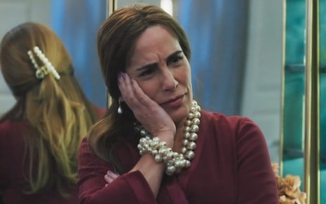 A atriz Gloria Pires está com a mão no rosto e faz uma expressão de deboche em cena da novela Terra e Paixão, da Globo