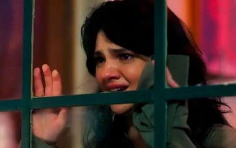 A atriz Debora Ozório está chorando agoniada em cena de Terra e Paixão como Petra