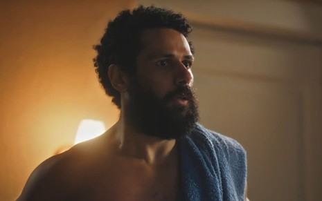 Amaury Lorenzo caracterizado como Ramiro; ele está sem camisa, com uma toalha sobre um dos ombros, em cena de Terra e Paixão