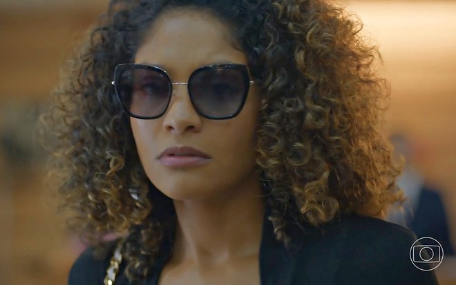 Débora (Barbara Reis) de óculos escuros na cena em que é presa na novela Todas as Flores