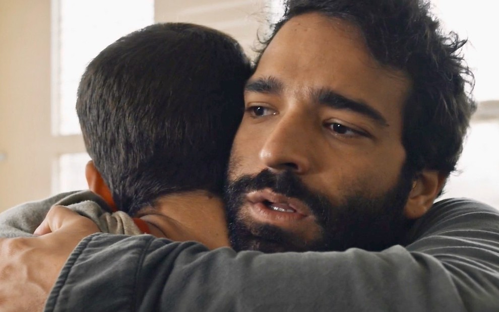 Nicolas Prattes (de costas) é abraçado por Humberto Carrão em cena da novela Todas as Flores, da Globo