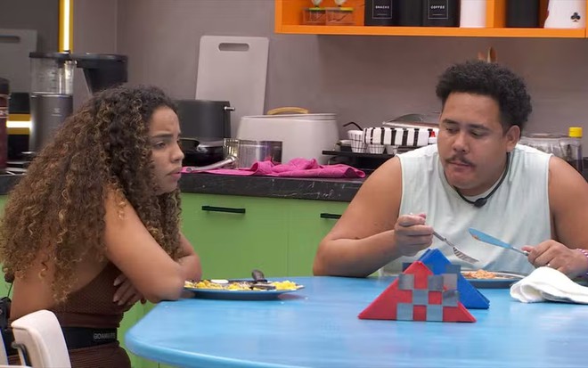 Giovanna Pitel e Lucas Henrique têm expressões derrotistas na mesa da cozinha do BBB 24