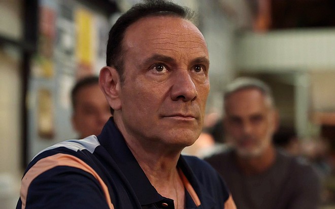O ator Marco Ricca está em close no ambiente de um bar em cena da série Justiça 2 como Nestor
