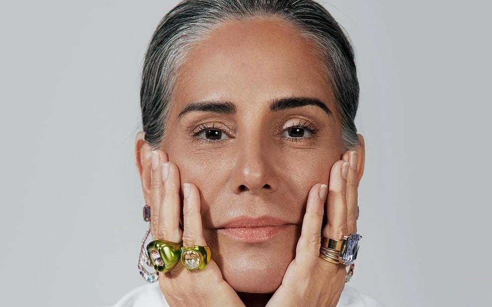 Gloria Pires está segurando o próprio rosto usando vários anéis