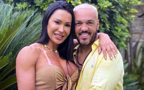 Gracyanne Barbosa e Belo estão abraçados e sorridentes