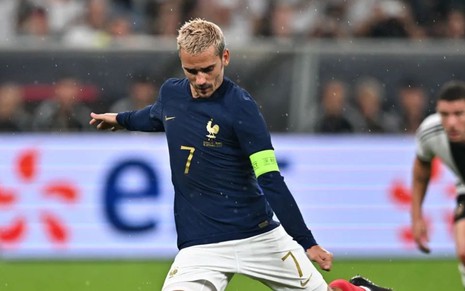 Antoine Griezmann chuta bola em jogo da França; ele usa uniforme azul