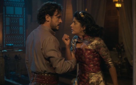 Salomão (Guilherme Dellorto) segura o braço de Naamá (Ingrid Conte) em cena da novela Reis