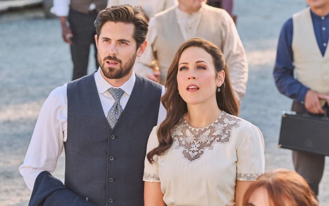 Chris McNally e Erin Krakow olham para cima com expressão de surpresa em cena da série Quando Chama o Coração