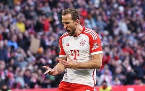 Atacante inglês Harry Kane pula e comemora gol do Bayern de Munique; ele usa uniforme branco e vermelho