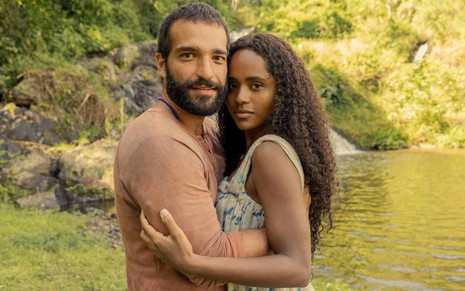 José Inocêncio (Humberto Carrão) e Maria Santa (Duda Santos) abraçados na beira de rio