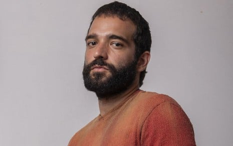 De barba, Humberto Carrão posa com uma blusa marrom