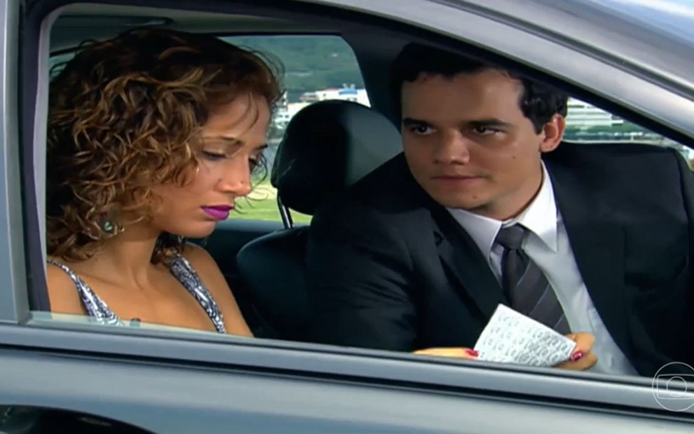 Os atores Camila Pitanga e Wagner Moura lado a lado em carro, com expressões sérias, em cena de Paraíso Tropical