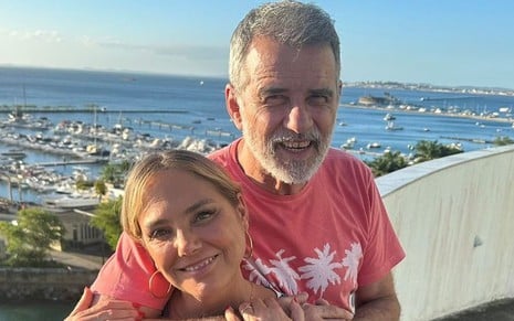 Heloisa Périssé e Mauro Farias posam abraçados em uma vista paradisíaca