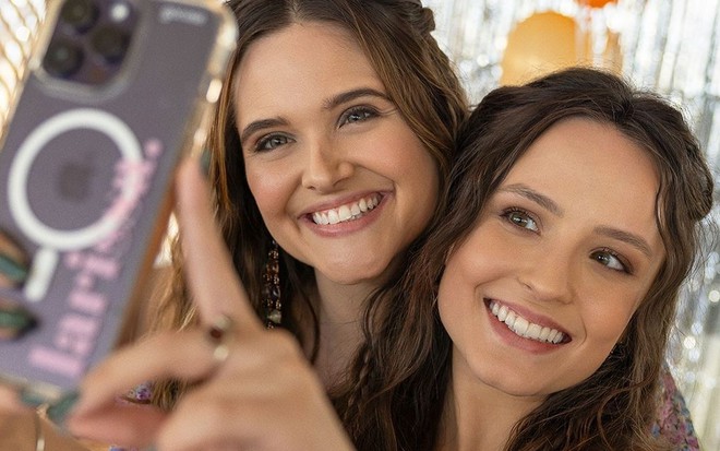 Juliana Paiva e Larissa Manoela sorriem enquanto tiram selfie em celular