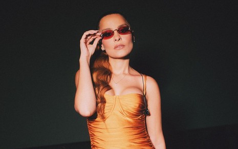 Maiara de vestido laranja e óculos escuros em foto no Instagram