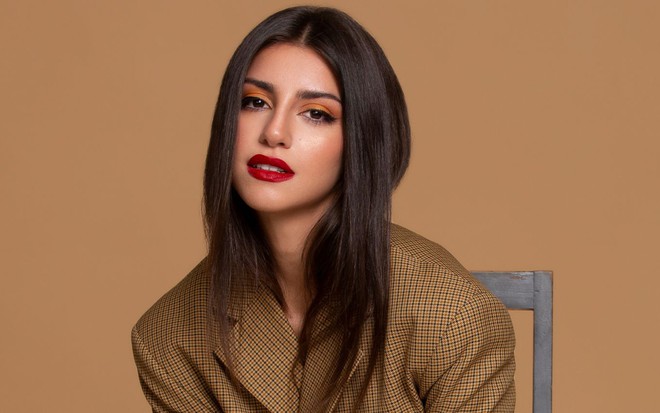 Isabela Souza está de cabelos soltos e usa batom vermelho em foto de divulgação