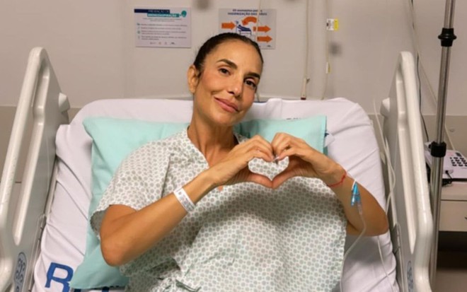 Ivete Sangalo faz o símbolo do coração em uma cama de hospital
