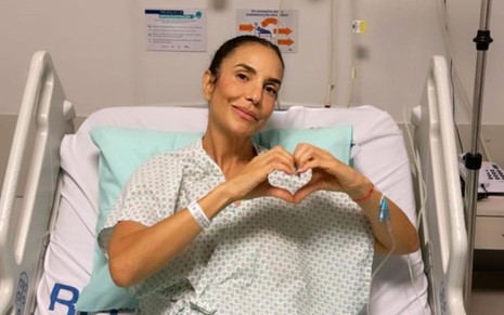 Ivete Sangalo faz o símbolo do coração em uma cama de hospital