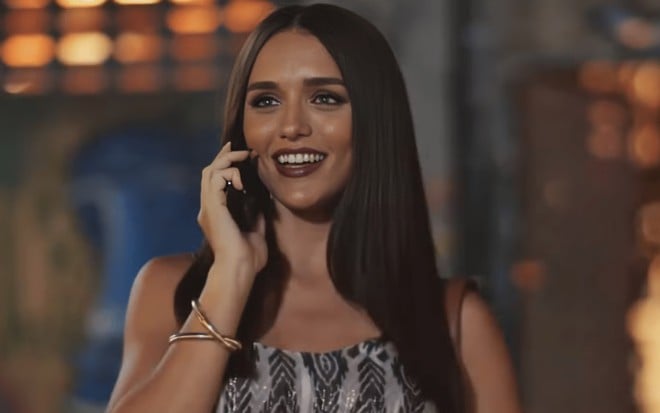 A atriz Rafa Kalimann com celular no ouvido, sorrindo em cena de Família É Tudo