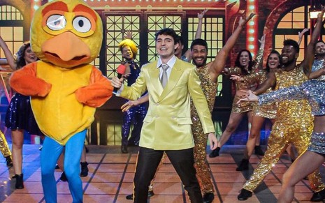 João Augusto Liberato vestido como Gugu dançando no palco do Domingão com o pintinho amarelinho