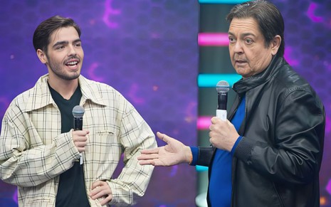 À direita, João Guilherme Silva fala no microfone enquanto olha para o pai, Fausto Silva, no programa do Faustão da Band