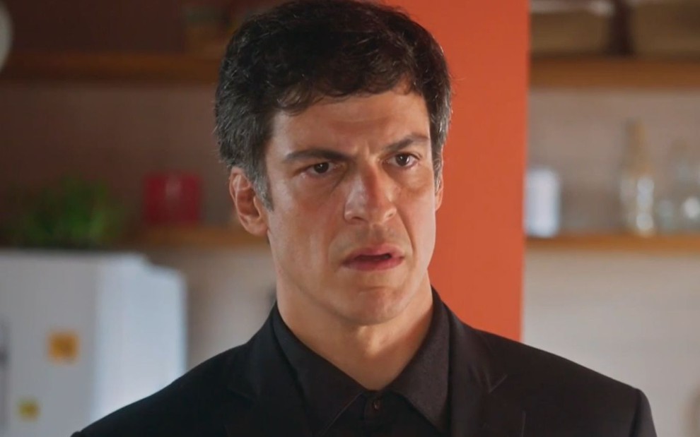 O ator Mateus Solano com expressão séria e consternada em cena de Elas por Elas