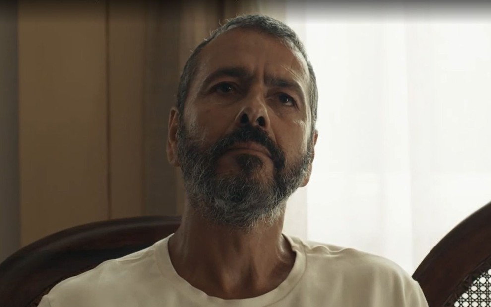 Em cena de Renascer, Marcos Palmeira está com a expressão séria; ele usa blusa branca